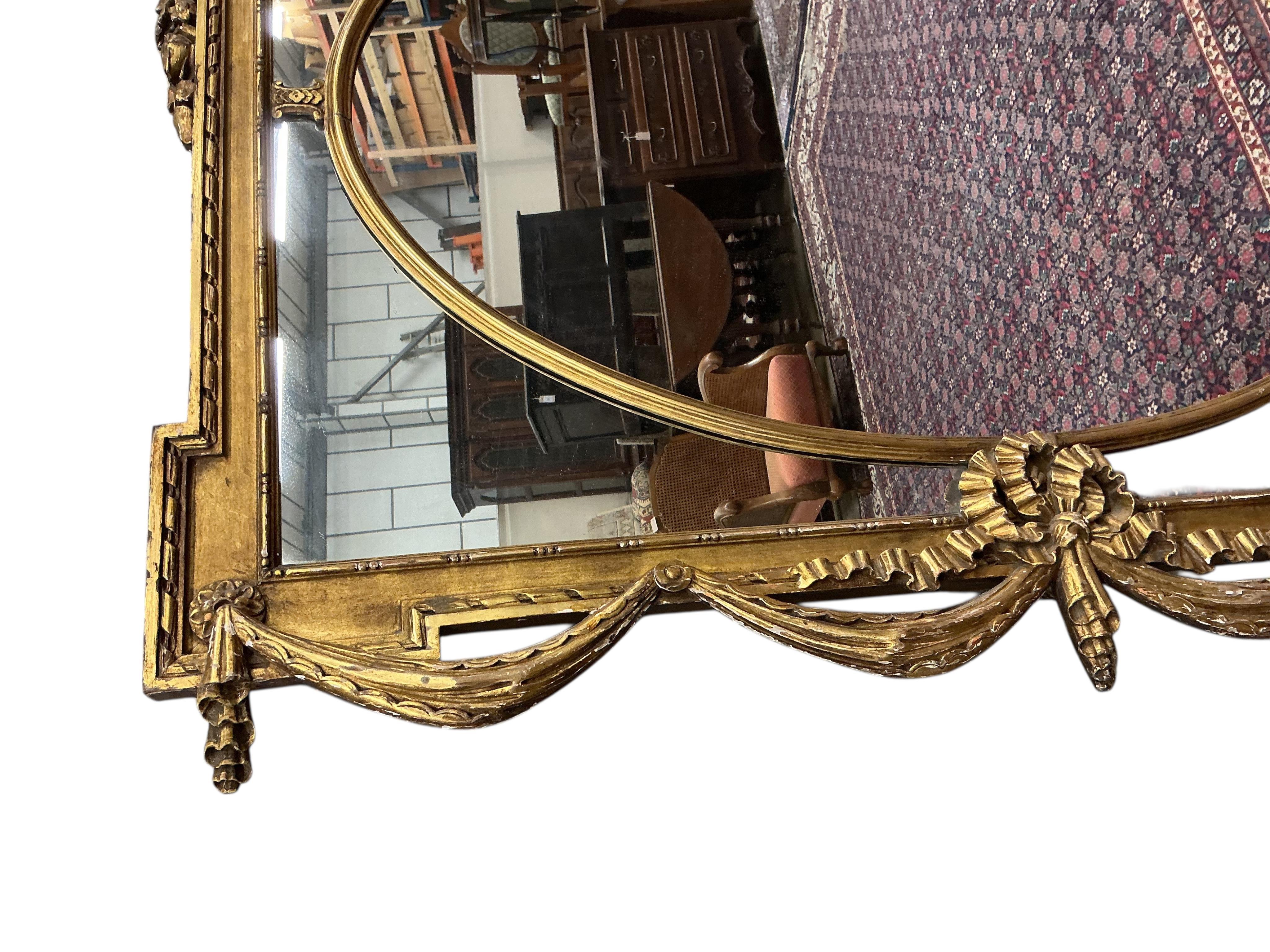 A Victorian style giltwood and composition overmantel mirror with cross torch and quiver crest, width 136cm, height 110cm
